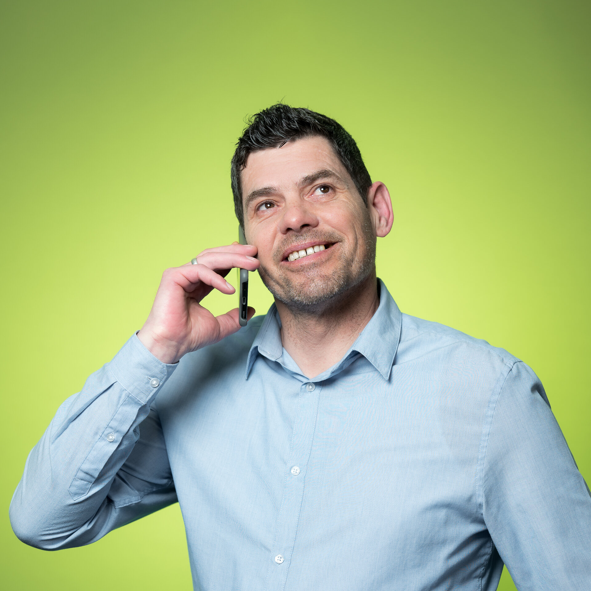 Erwin Kaiser telefoniert mit Handy am Ohr und schaut dabei lächelnd nach oben. | © Bamboo Health Care GmbH
